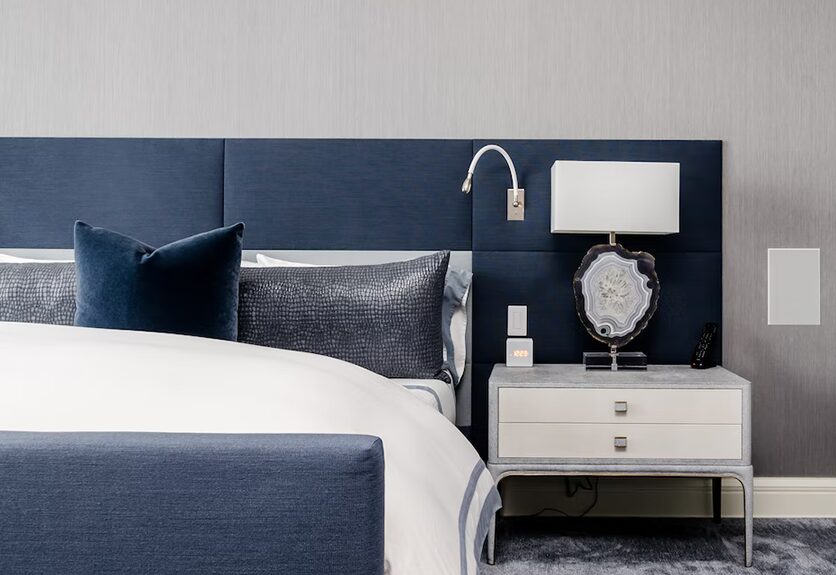 Deluxe room with navy upholstered headboard at Mahakal Dharmshala, Ujjain